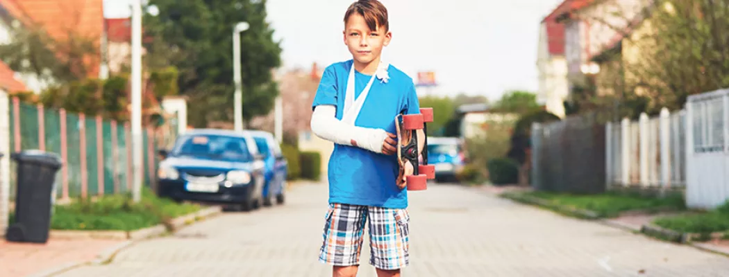 Boy with skateboard and broken arm